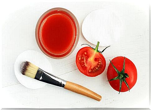 Tomatoes and tomato juice on a table along with a makeup brush