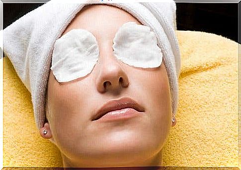 A lady lying with pads on her eyes