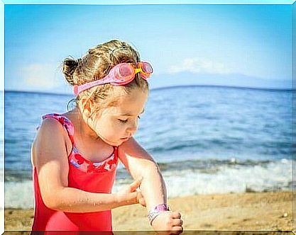 A girl looking at spots on her arm.