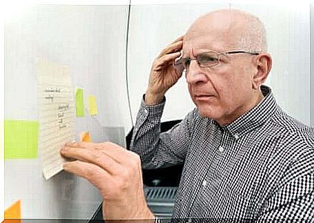 An elderly man looking at a list with a confused expression.