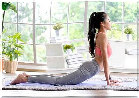 A woman practicing yoga in her home.