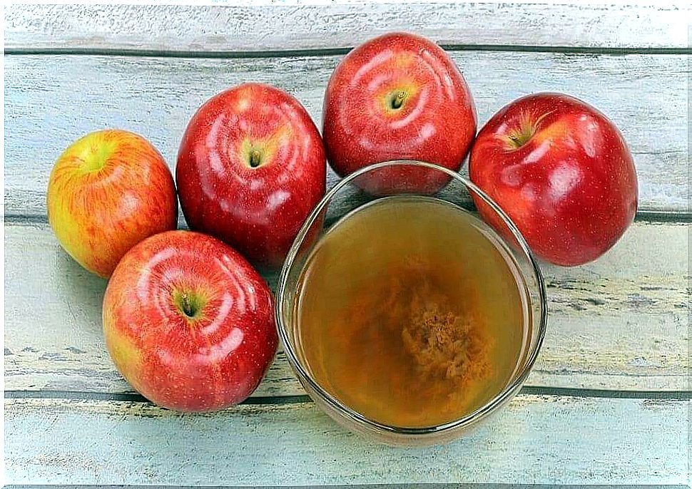 apple cider vinegar surrounded by apples