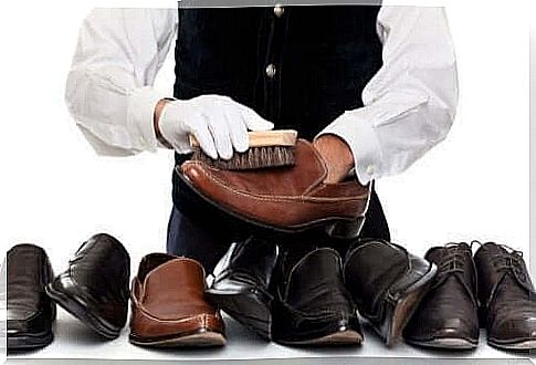 Professional shoemaker with many pairs of clean leather shoes