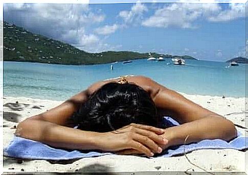 A woman sunbathing on a beach