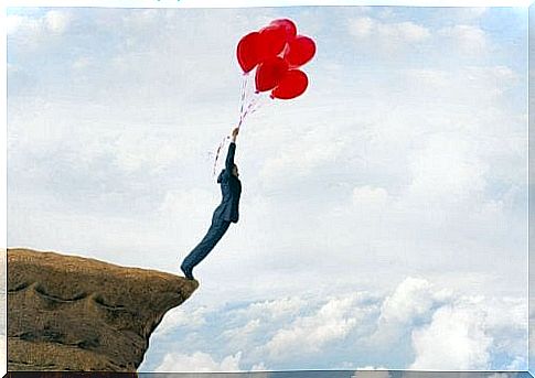 Man with balloons on rock