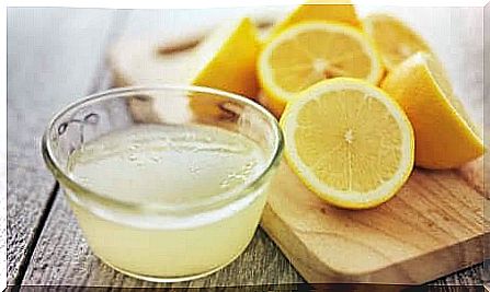 Lemon juice and lemons standing on a kitchen counter.