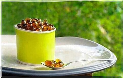 lecithin supplement capsules in a container and on a spoon.