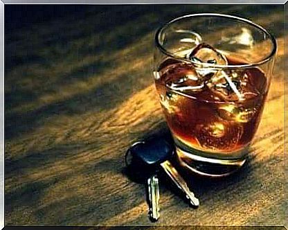 Car keys lying next to a glass of whiskey