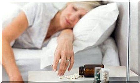 woman sleeping next to sleeping pills